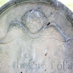 Winged cherub on grave marker.