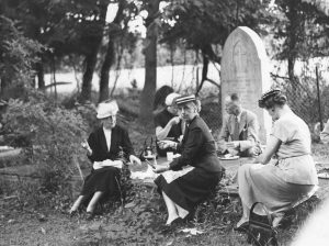 People picnic in a cemetery.