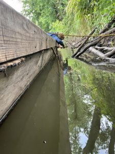 Prior to getting underway, Sebastian tightens up the caulking in a seam. Natural fiber, rolled into a loose rope, is hammered in between planks to keep water out. The natural shrinking and swelling of the wood requires constant attention to the seams to keep the boats dry.