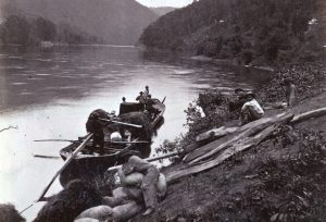 The batteau 'Tam O Shanter' is seen here in June of 1872 on the bank of the New River. Unlike the James, the New River was never canalized and river traffic was limited to batteau. Note the mixed cargo, which appears to include hay. A man in the boat is holding a speaking trumpet, used to communicate with people on shore to arrange a landing to pickup or discharge cargo.
