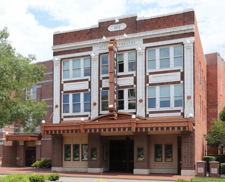 Photo of a building facade of the theater. It's a three story building with large windows and an awning.